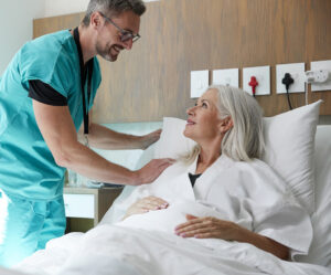 Surgeon Visiting And Talking With Mature Female Patient In Hospital Bed