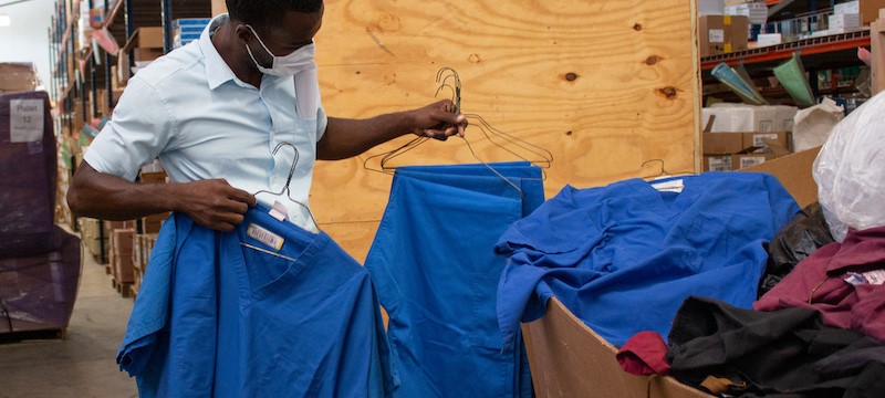 A man hold scrubs, donated by ImageFIRST
